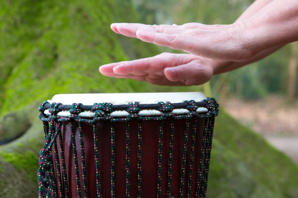Handen spelen op een djembe trommel tijdens muziektherapie